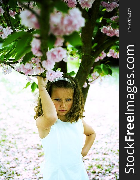 Cute little girl holding a branch of a tree. Cross-processed. Cute little girl holding a branch of a tree. Cross-processed