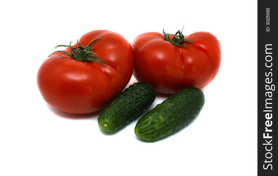 Fresh tomatoes and cucumbers on a white background. Fresh tomatoes and cucumbers on a white background