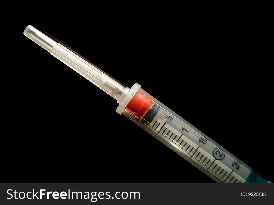 A 3cc syringe with the top on shot on a ultra black background. A 3cc syringe with the top on shot on a ultra black background