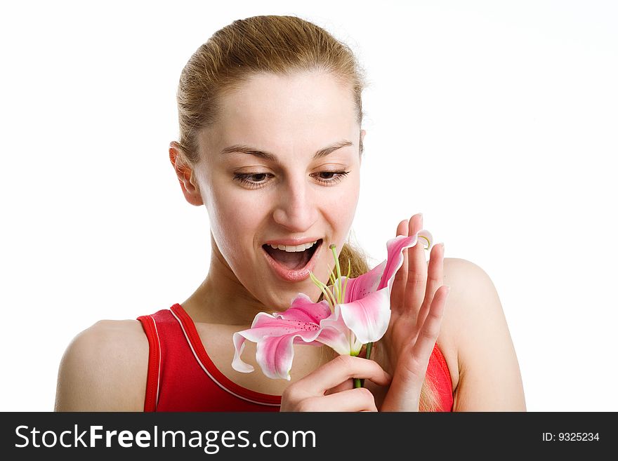 A nice blond girl in red posing with a pink lily near her face on a white background. A nice blond girl in red posing with a pink lily near her face on a white background