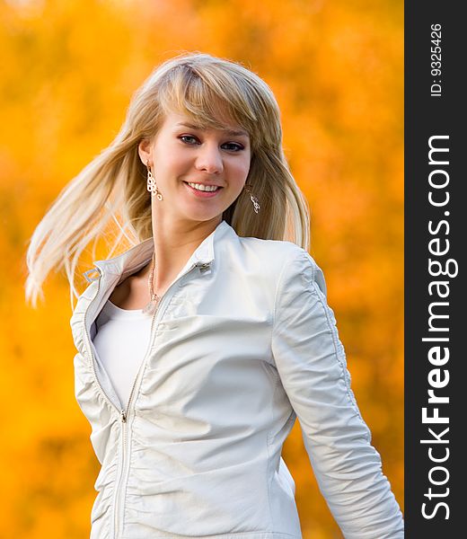 Pretty girl in white jacket on autumn park background - shallow DOF