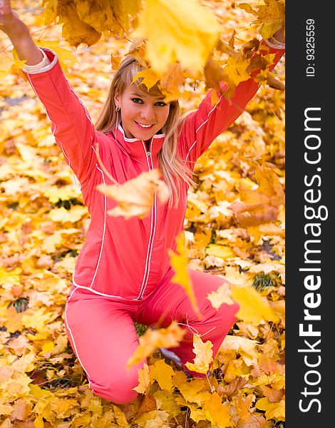 Pretty girl playing with yellow maple leaves - shallow DOF