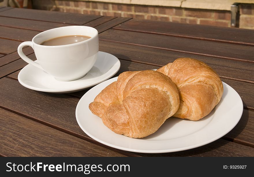 Croissant with a cup of coffee on table