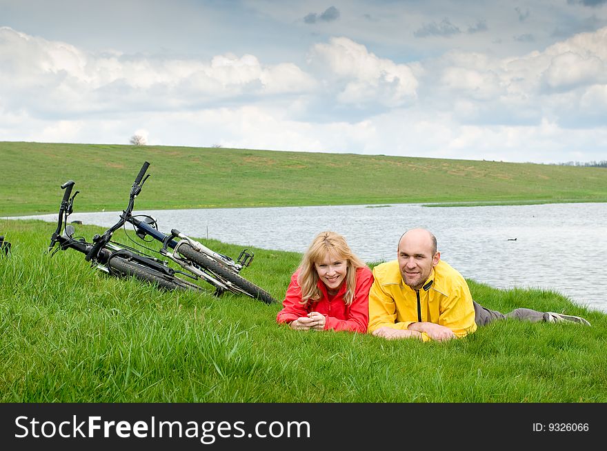 Two cyclists on river bank