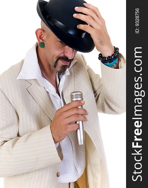 Portrait of alternative man with jade earrings, microphone and fedora, studio shot