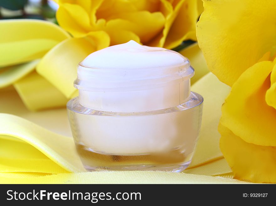 Beauty cream with rosebud and petals on white background