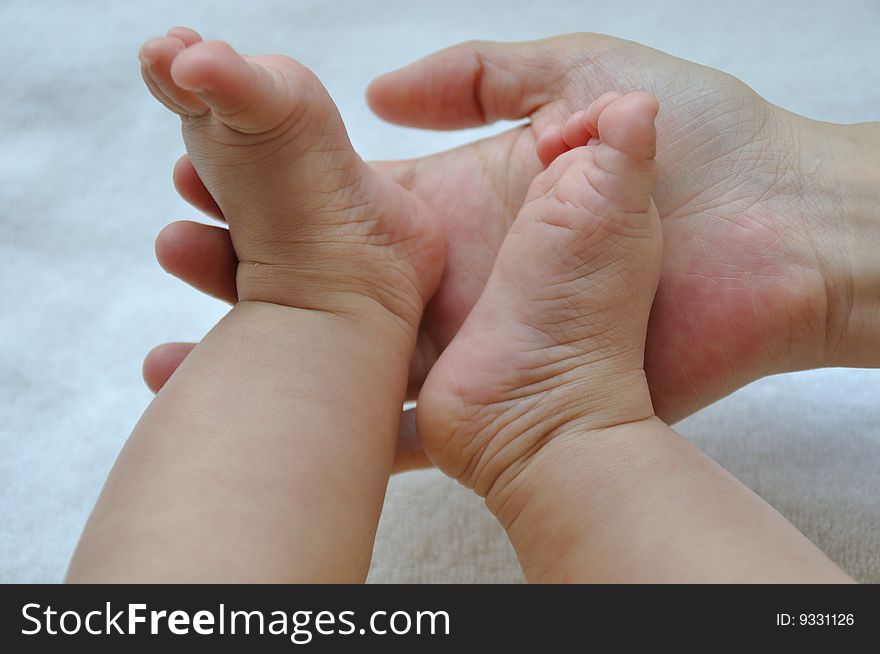 Hands and feet touch between chinese mother and baby show family and love. Hands and feet touch between chinese mother and baby show family and love.