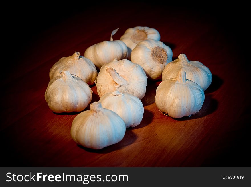 A small batch of garlic bulbs on a dark table