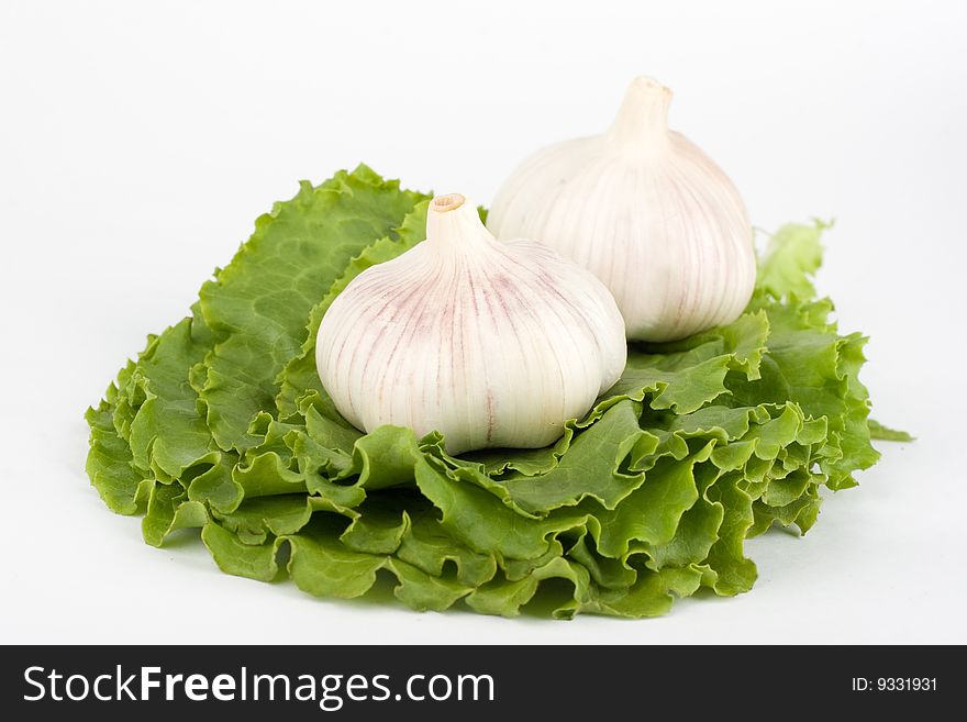 Garlic on the leaves of lettuce  on the  white background. Garlic on the leaves of lettuce  on the  white background