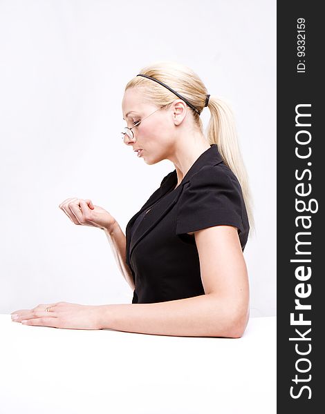 Blonde woman with the glasses looking at her nails, bored. Blonde woman with the glasses looking at her nails, bored