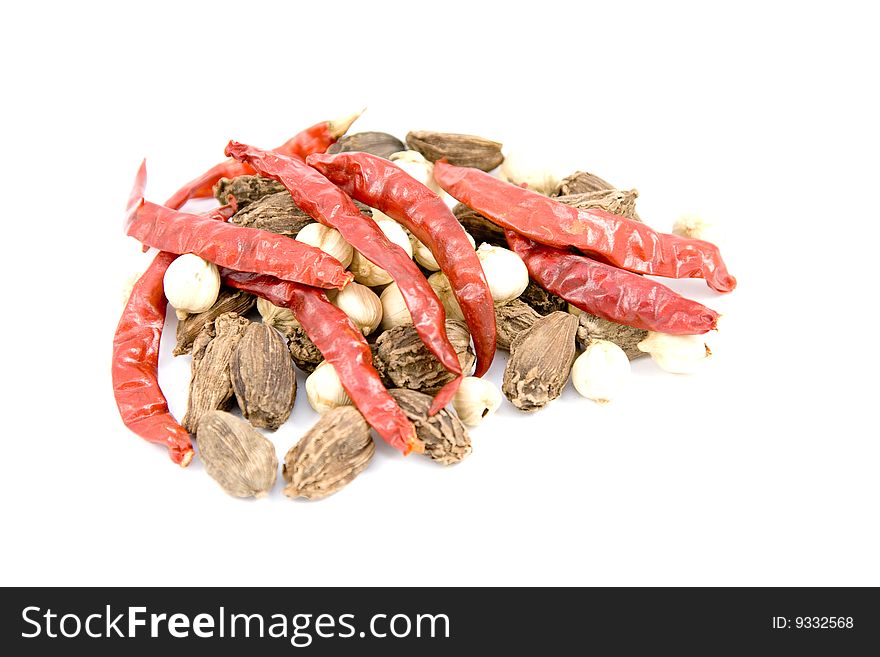 Dried red pepper and cardamom on a white background