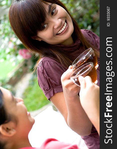 Two happy asian women having an afternoon tea together in the garden, celebrating their friendship. Two happy asian women having an afternoon tea together in the garden, celebrating their friendship