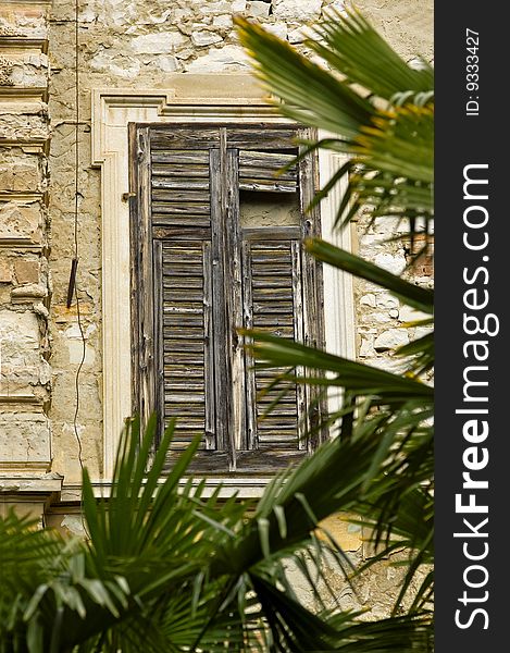 Tipical old window in mediterran area with palms
