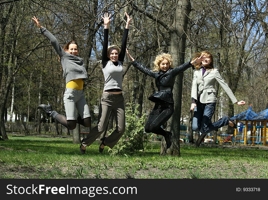 Four girls jumping on the street