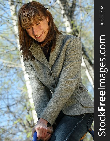 Happy woman on a swing in the park