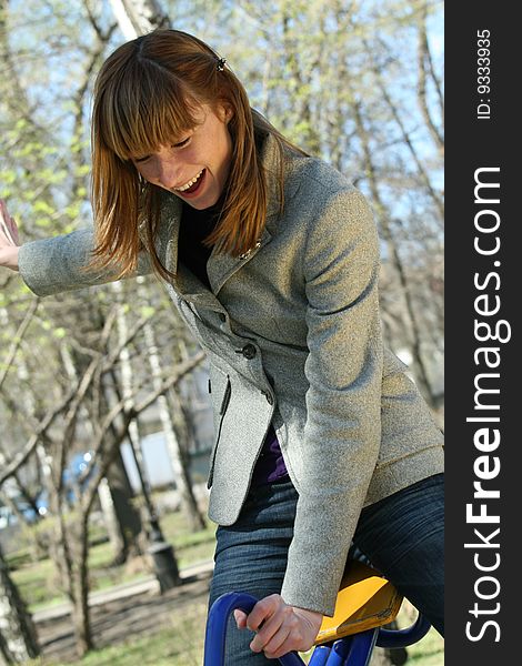 Happy woman on a swing in the playground