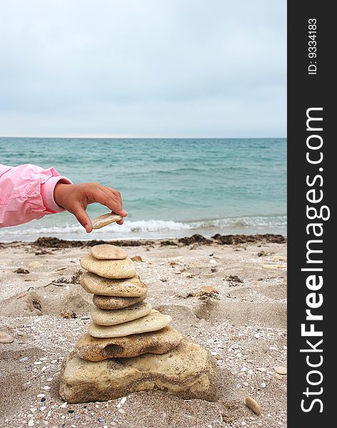 Stack of pebbles over sea background