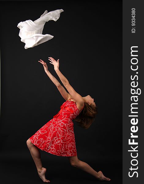 Elegant young flexible woman in red-white outfit with white scarf