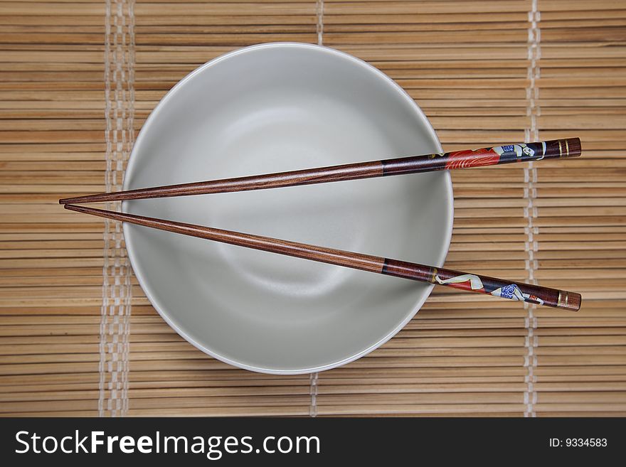 Closeup of chopsticks resting on a bowl. Closeup of chopsticks resting on a bowl