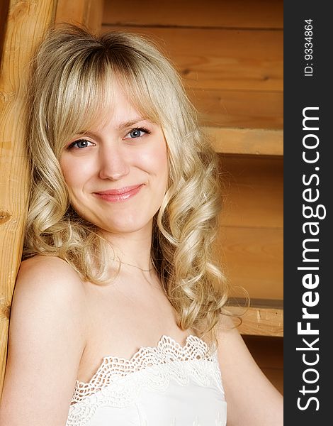 Portrait of the charming blonde on a wooden ladder background. Portrait of the charming blonde on a wooden ladder background