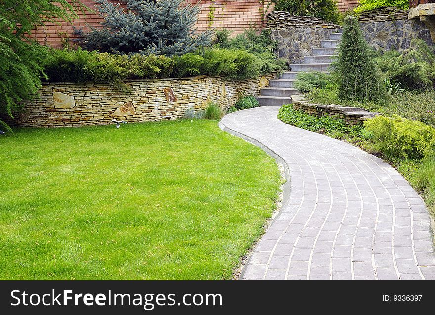 Garden stone path with grass growing up between the stones