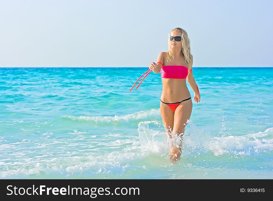 Blonde girl going out of the sea. Blonde girl going out of the sea