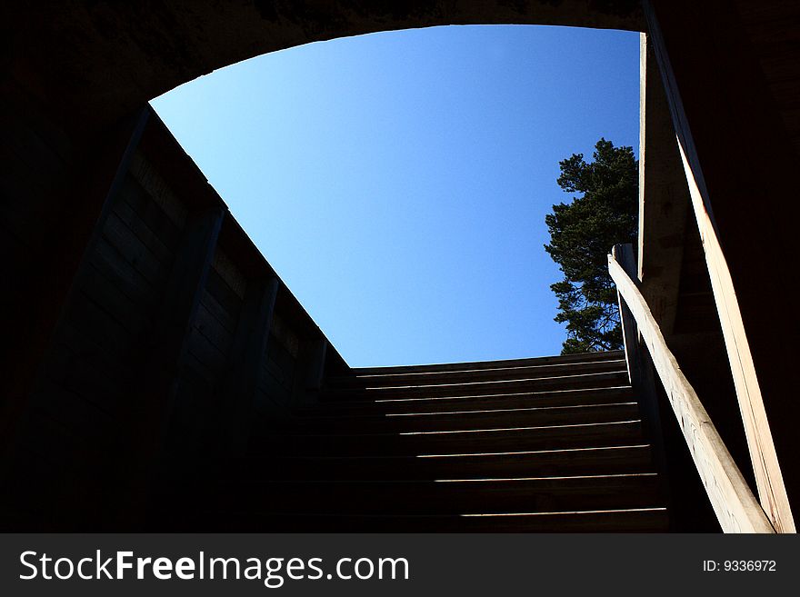 Stairs in dark space with blue sky in hatchway