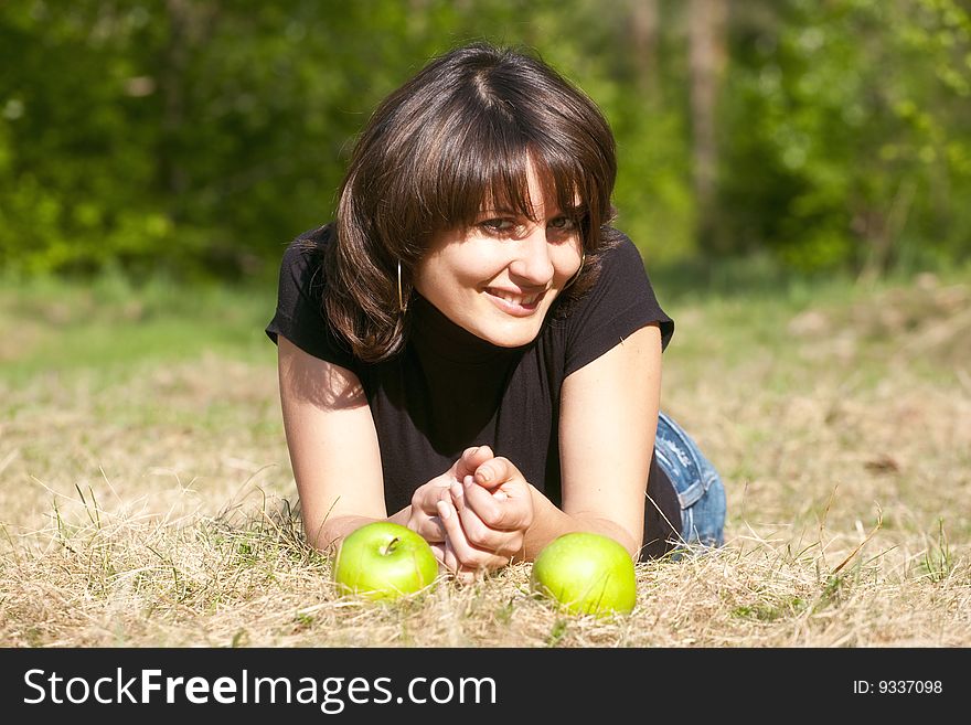 The beautiful girl with apples in a sunlight