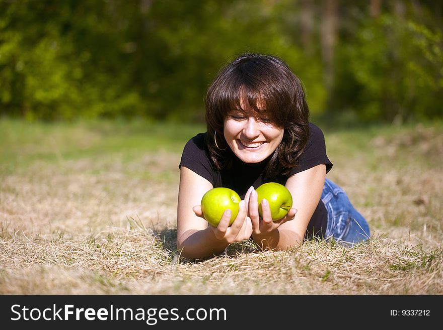 The beautiful young girl with two apples in hands