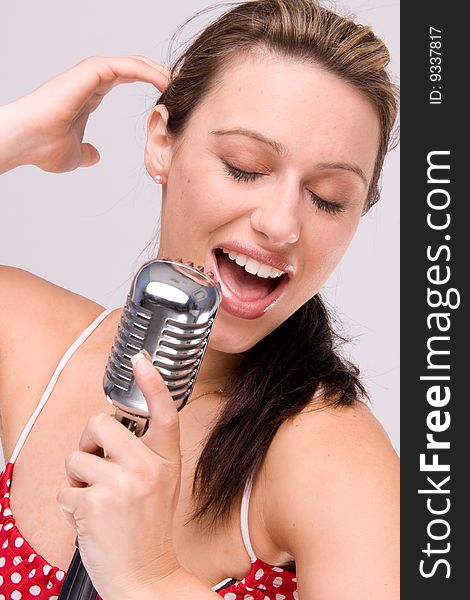 Sexy women in dotty red dress with microphone close-up. Sexy women in dotty red dress with microphone close-up