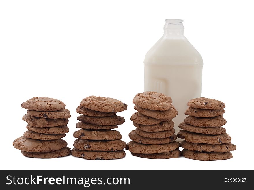 Chocolate chip cookies in four stacks, with a bottle of milk behind. Chocolate chip cookies in four stacks, with a bottle of milk behind