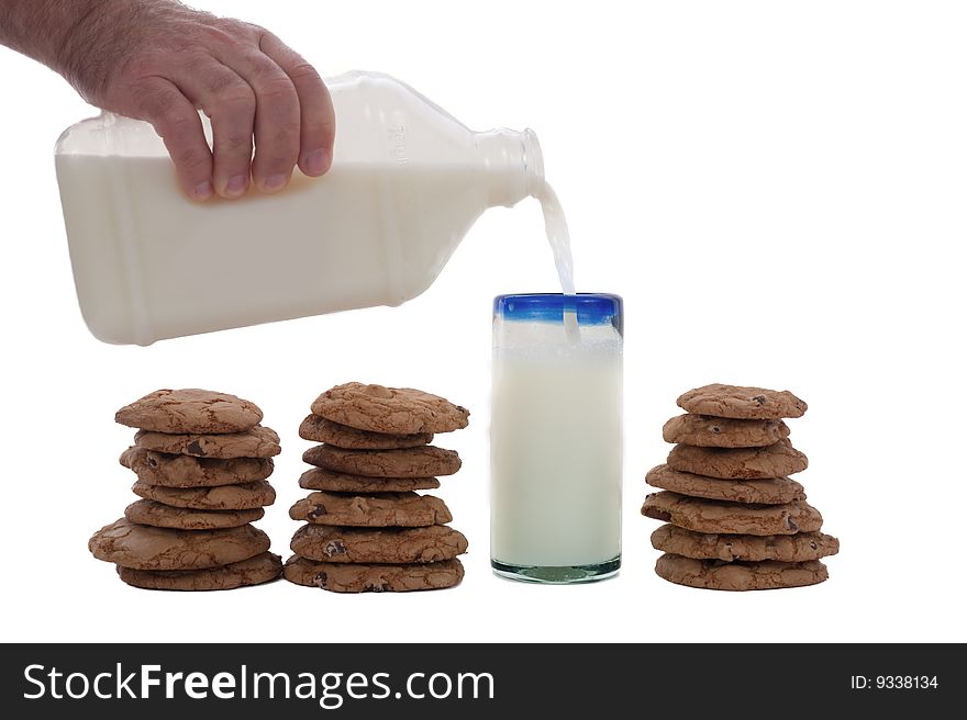 Cookies arrange in a row, with a glass of milk being poured from a bottle. Cookies arrange in a row, with a glass of milk being poured from a bottle