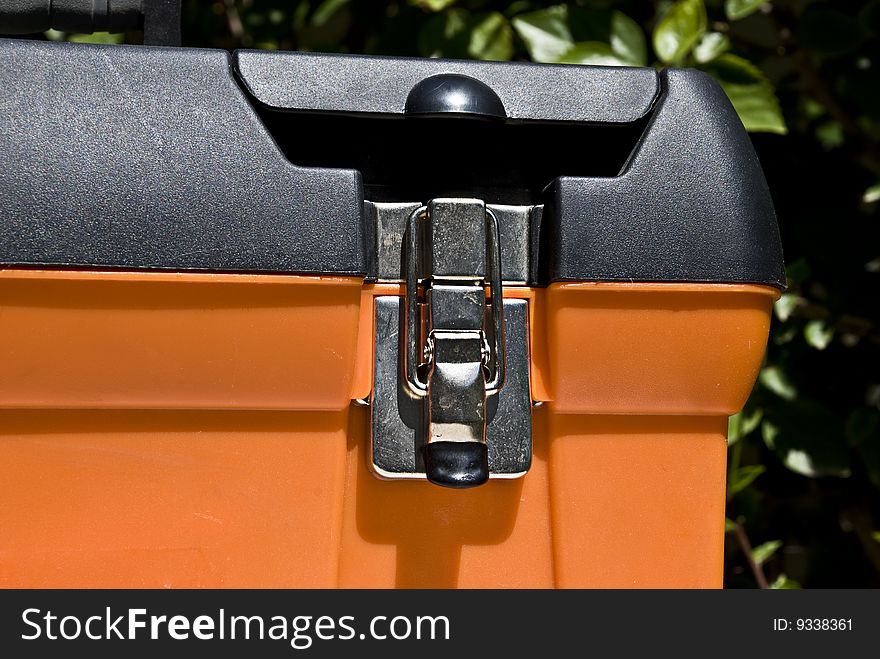 Close-up of a locked orange toolbox. Close-up of a locked orange toolbox