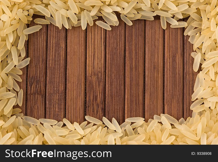 Frame of uncooked rice on bamboo mat with copy space. Frame of uncooked rice on bamboo mat with copy space.