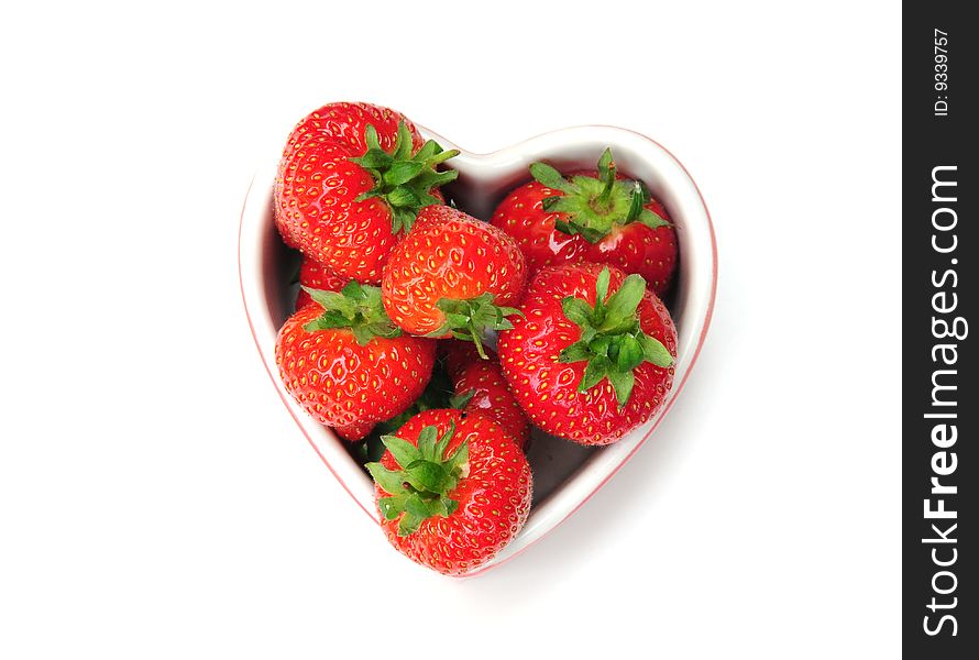 Some delicious strawberries in a heart shaped dish