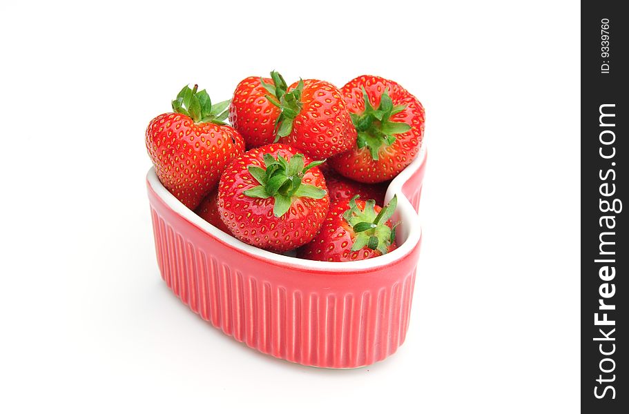 Some delicious strawberries in a heart shaped dish