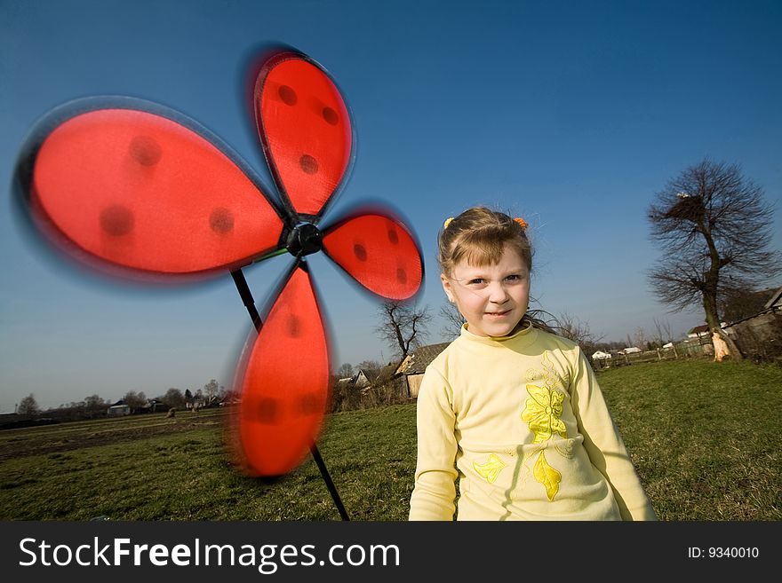 Smiling little girl with a windmill toy
