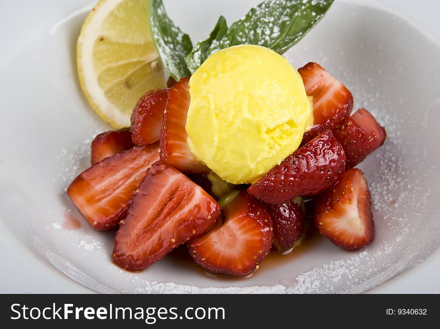 Peach or mango icecream sundaes with strawberries, outside at summertime.