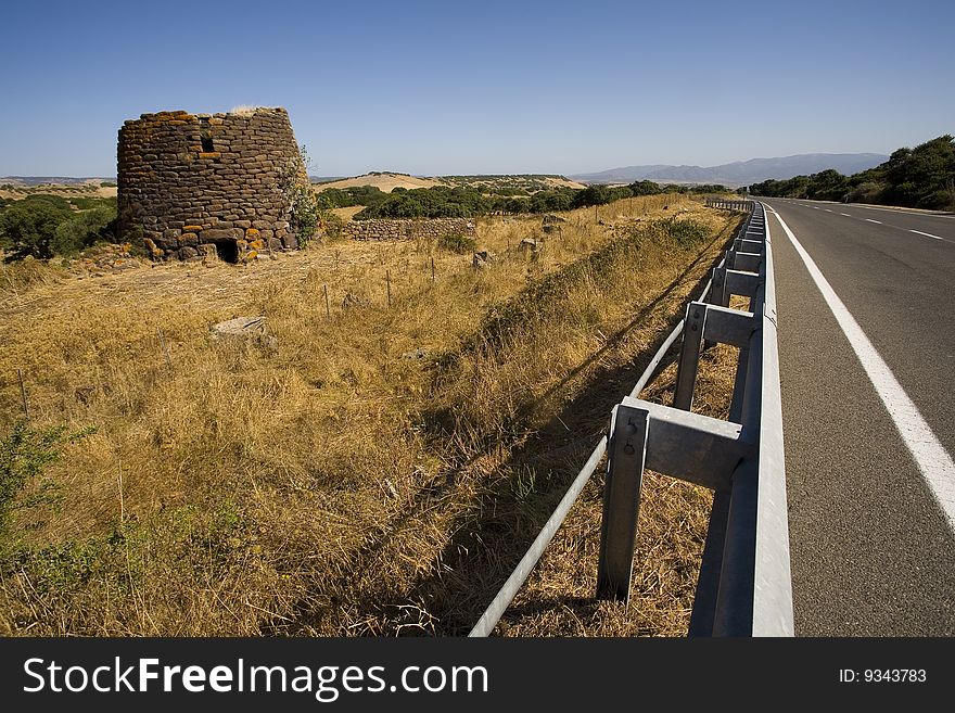 Nuraghe of Sardinia in the summer near a highway