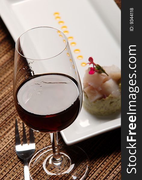 Raw fish on plate decorated with glass of wine. Raw fish on plate decorated with glass of wine