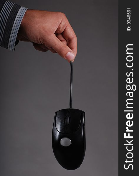 A male hand holding a computer mouse. A male hand holding a computer mouse