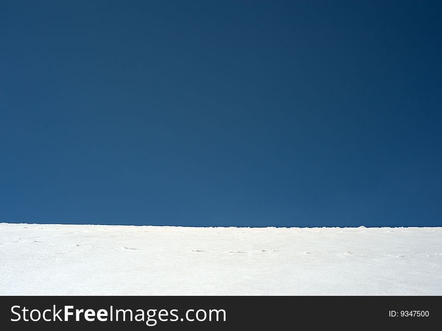 Blue sky horizon with white snow structure. Blue sky horizon with white snow structure