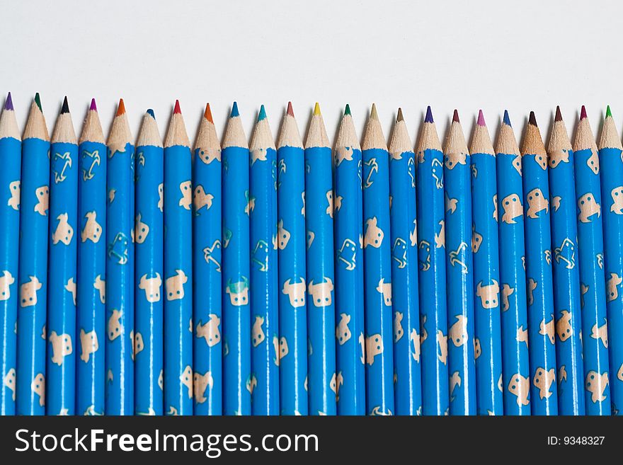 Stack of wooden crayon inside a tube case with one standing out. Stack of wooden crayon inside a tube case with one standing out