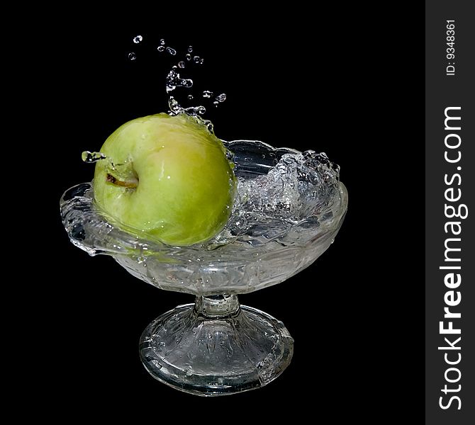 Apple falls into water over black background