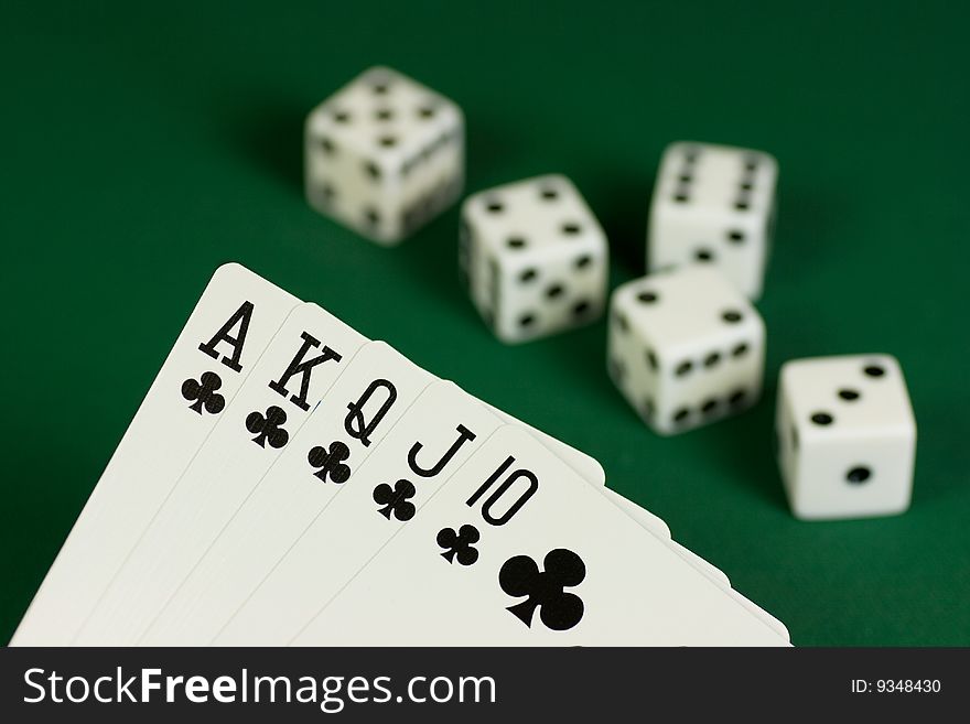 Royal Flush Clubs and dices on green background