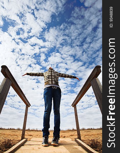 Young girl in jeans against blue sky. Young girl in jeans against blue sky