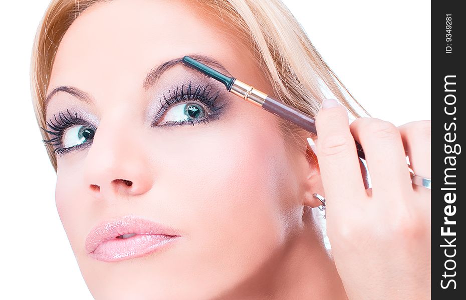 Nice caucasian model applying makeup with brush, isolated on white background