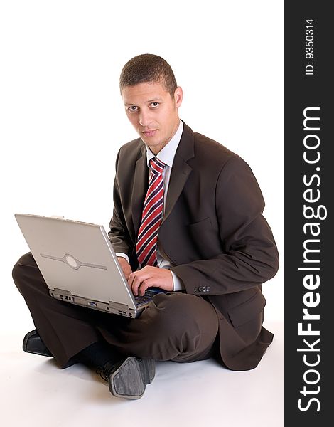 Businessman sitting on the floor with laptop on his knees. Businessman sitting on the floor with laptop on his knees