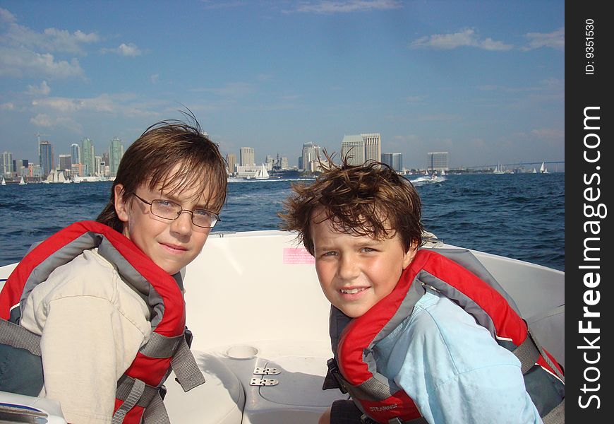 Two boys sitting in a boat with the San Diego Skyline in the background. Two boys sitting in a boat with the San Diego Skyline in the background