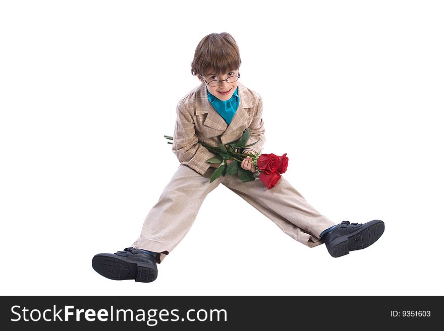 The boy of 7-years sits with a bouquet of roses looks in the chamber on the white isolated background. The boy of 7-years sits with a bouquet of roses looks in the chamber on the white isolated background